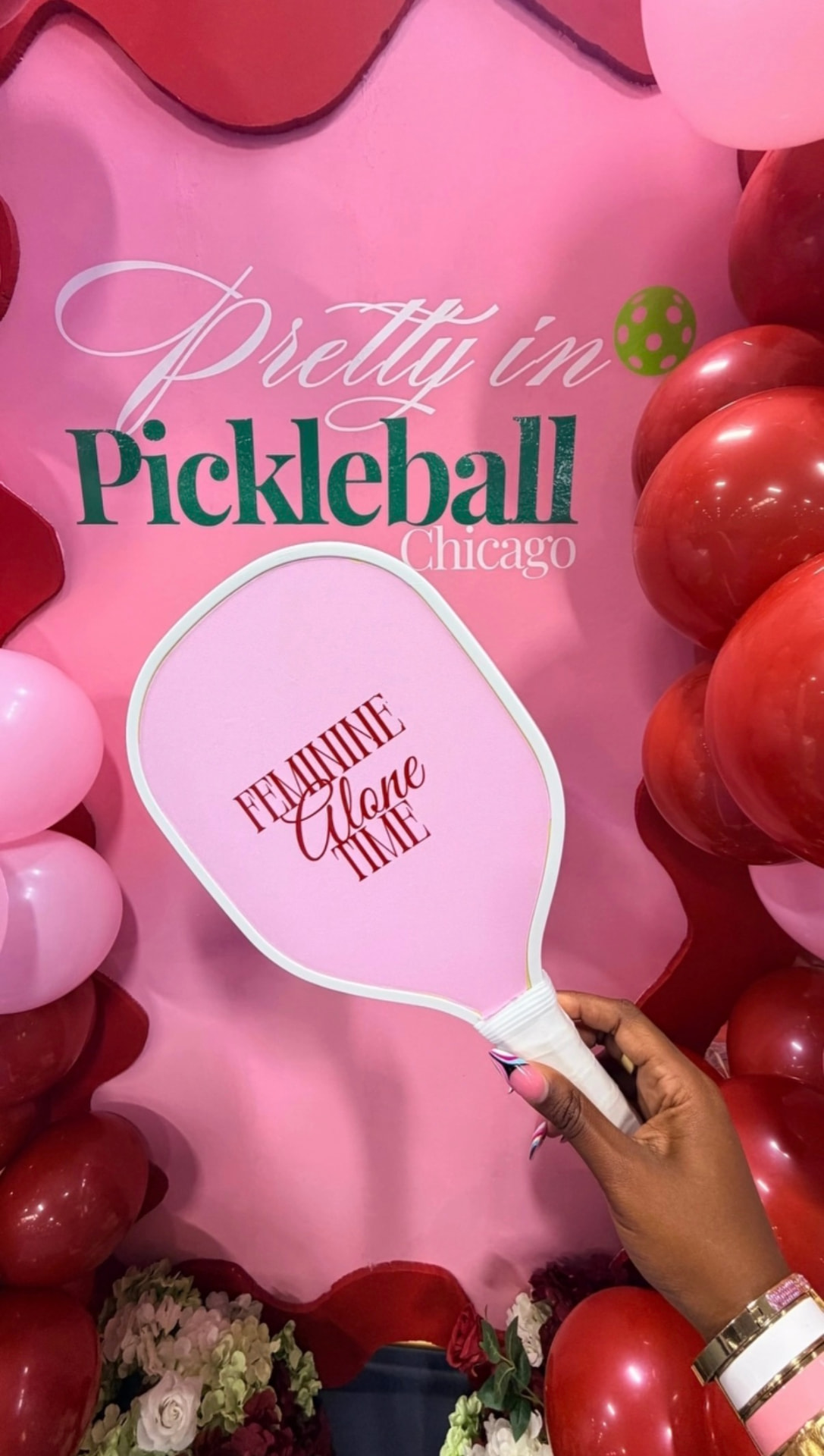 Feminine Alone Time branded paddle against the Pretty in Pickleball Chicago balloon backdrop